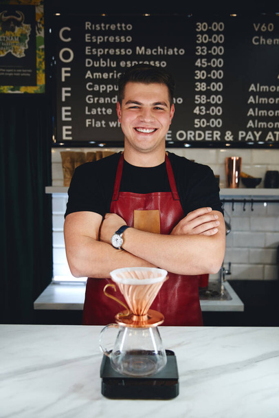 Barista making a drip coffee, pouring hot water from kettle over a coffee powder - Foto, afbeelding