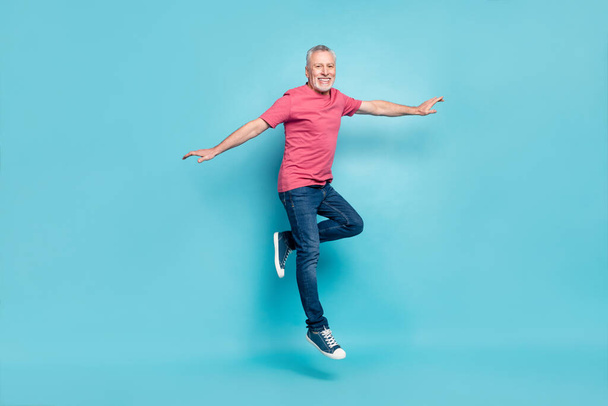 Full length body size view of nice cheerful middle-aged man jumping having fun isolated over bright blue color background - Foto, Bild