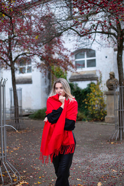 Thinking european white young woman with blonde hair in red scarf in autumn - Fotó, kép