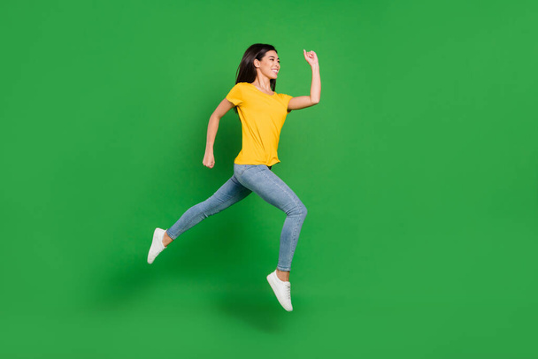 Full size profile side photo of charming pretty young woman jump up run empty space isolated on green color background - Фото, изображение