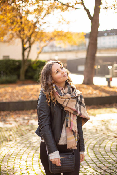 Looking up and smiling european white young woman with brown hair walking in autumn - Foto, Bild