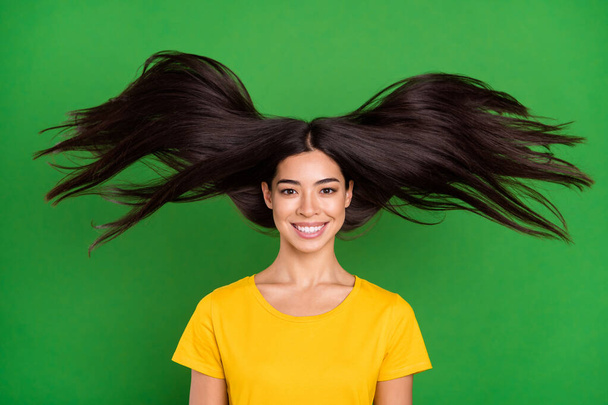 Photo of charming pretty young woman good mood wind blow hair wear casual clothes isolated on green color background - 写真・画像