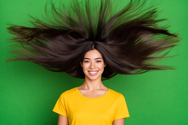 Photo of positive happy nice young woman smile good mood fly long hair isolated on green color background - 写真・画像