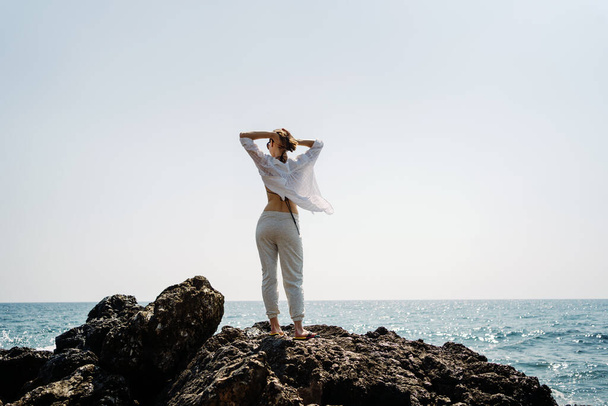 Traveler woman enjoys her vacation on sea coast - Foto, Bild