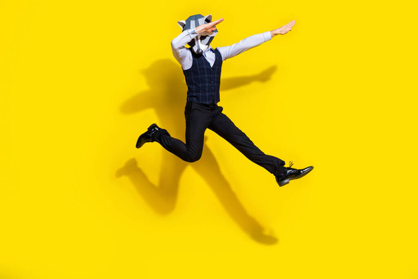 Full body photo of absurd surreal wacky guy racoon mask jump dance dabber wear trendy outfit isolated over yellow color background - Foto, Imagen
