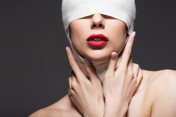 woman in elastic bandage, bare shoulders and red lips isolated on grey - Photo, Image