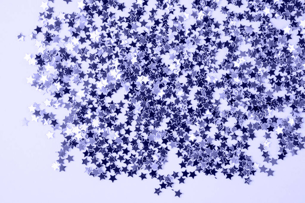 Color of the Year 2022 Very Peri. Trendy background made of shiny star shaped confetti. Fashion purple shade, copy space - Photo, Image