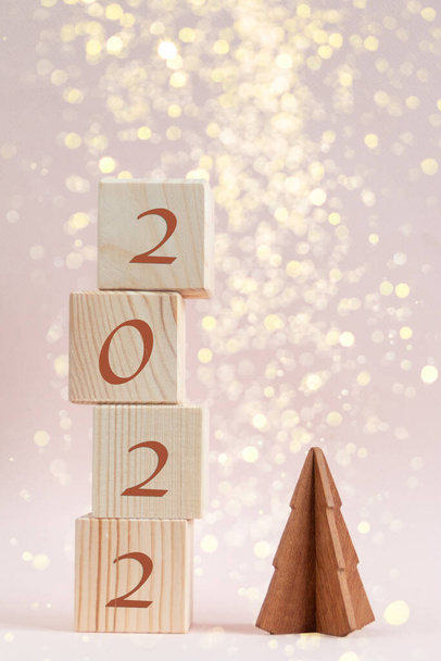 Ξύλινοι κύβοι πυραμίδα με αριθμούς νέο έτος και λάμπει λάμψη bokeh - Φωτογραφία, εικόνα