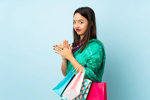 Young Indian woman with shopping bags scheming something - Zdjęcie, obraz