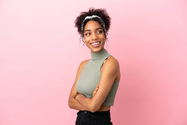 Young latin woman isolated on pink background with arms crossed and happy - Fotó, kép