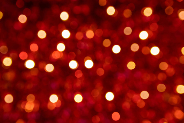 Εορταστική κόκκινο αφρώδη bokeh φόντο με λαμπερά αστράφτει και πολύχρωμες τελείες ως τέλειο φόντο για τα Χριστούγεννα, silvester, γιορτή και ευτυχισμένο το νέο έτος σχόλια ως όμορφη θολή λάμψη - Φωτογραφία, εικόνα