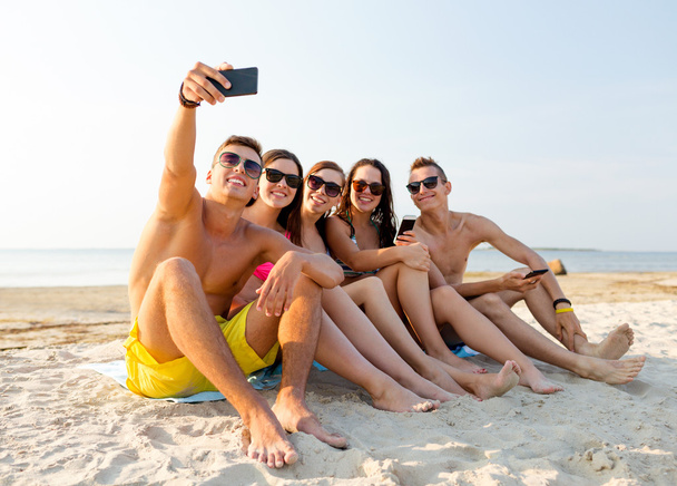 friends with smartphones on beach - Фото, зображення