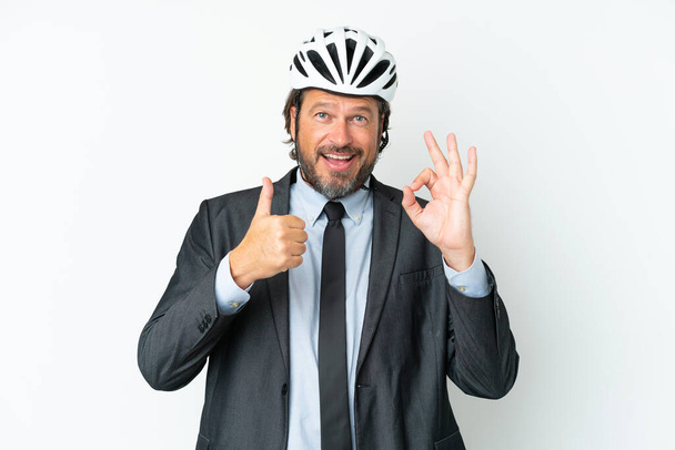 Business vanhempi mies pyörä kypärä eristetty valkoisella taustalla osoittaa ok merkki ja peukalo ylös ele - Valokuva, kuva