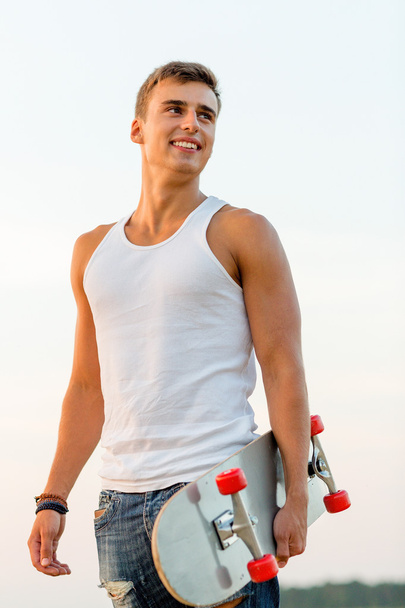 smiling teenage boy with skateboard outdoors - Zdjęcie, obraz