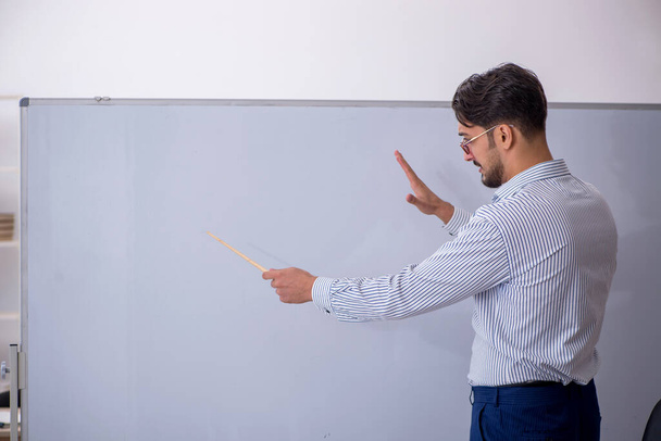 Jonge mannelijke leraar in de klas - Foto, afbeelding