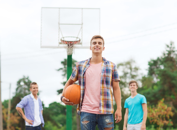 group of smiling teenagers playing basketball - Foto, afbeelding