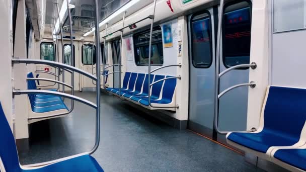 Ein leerer U-Bahn-Wagen fährt durch einen Tunnel. Niemand sitzt auf blauen Stühlen - Filmmaterial, Video