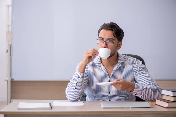 Mladý muž učitel pití kávy během přestávky - Fotografie, Obrázek