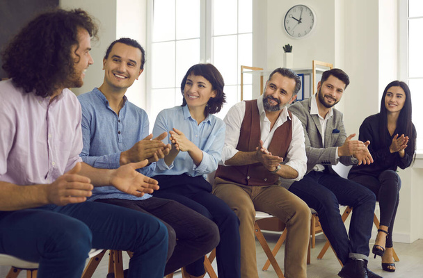 Group of happy people thanking coach or coworker for interesting talk in business meeting - Photo, Image