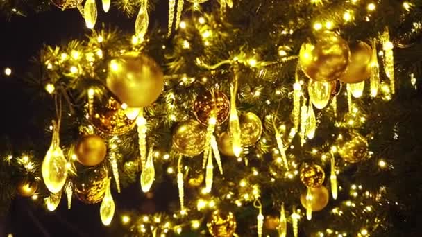 Hermoso salvapantallas de Navidad. Cierra las luces de un árbol de Navidad brillando por la noche. El abeto de Año Nuevo con adornamientos y la iluminación. Fondo decoraciones árbol de Navidad. Muchas grandes bolas de oro en - Imágenes, Vídeo
