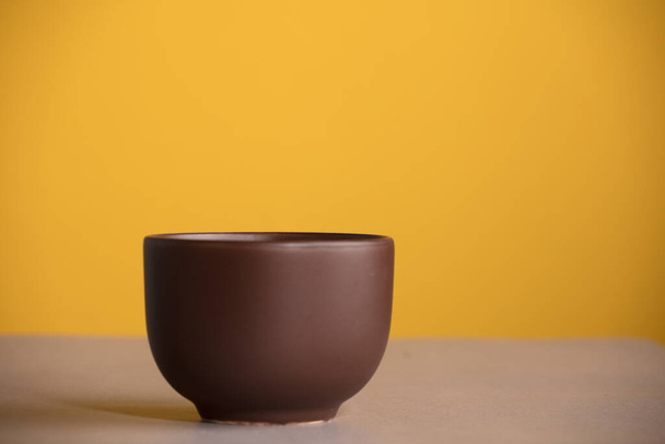 brown cup with coffee or chocolate, with yellow background - Valokuva, kuva