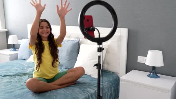dance tutorial of cheerful teen kid blogger making video on smartphone and ring lamp at home, blog - Footage, Video