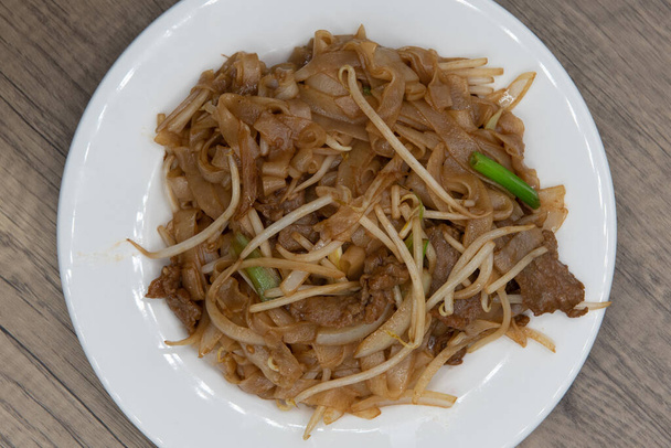 Yleisnäkymä naudanlihan chow mein nuudelit tekee valtava kasa lautaselle herkullista kiinalaista ruokaa kokemus. - Valokuva, kuva