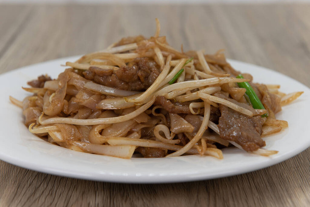 Naudanliha chow mein nuudelit tekee valtavan kasan lautaselle herkullista kiinalaista ruokaa varten.. - Valokuva, kuva