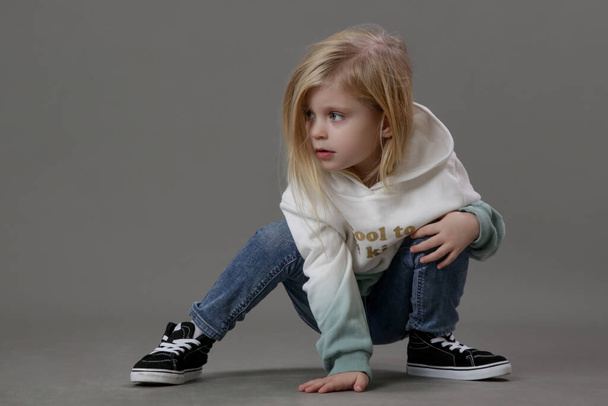 Studio portrait of toddler girl in jeans and hoodie - Photo, image
