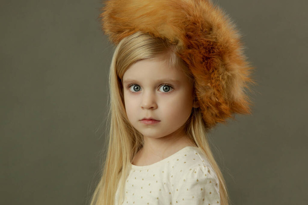 Студійний портрет красивої дівчинки в хутряній шапці
 - Фото, зображення
