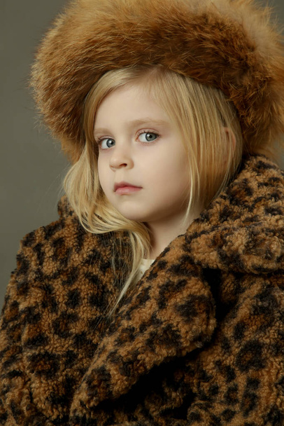 Studio portrait of beautiful little girl wearing fur hat - Photo, Image