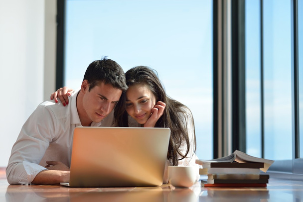 Entspanntes junges Paar arbeitet zu Hause am Laptop - Foto, Bild