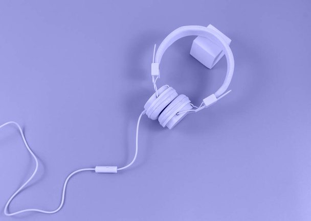 Headphones on a Very peri background. Trendy color of the year. Music, technology concept - Photo, Image