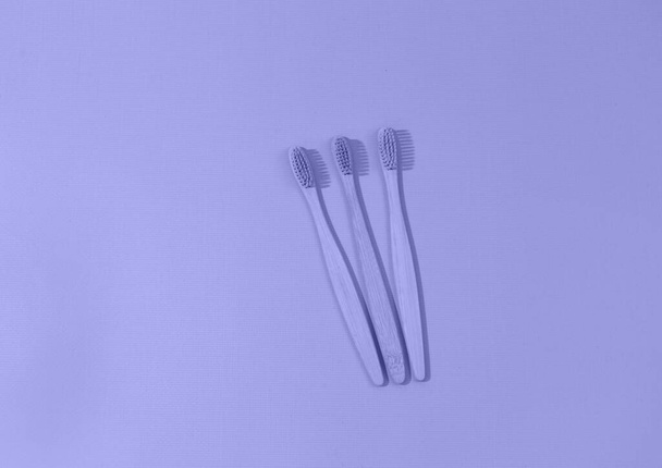 Κοντινό πλάνο των ξύλινων οδοντόβουρτσες μπαμπού σε πολύ Peri μοντέρνο χρώμα φόντο, το χρώμα του έτους 2022. Υγειονομική περίθαλψη, μηδενικά απόβλητα. Άνω όψη - Φωτογραφία, εικόνα