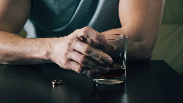 Young drunk man looks at wedding ring and decides to divorce - Photo, Image