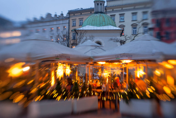 KRAKOW, POLAND, DECEMBER 9, 2021: Traditional street market near Church of St Wojciech and Statue of Polish poet Adam Mickiewicz in Main Market Square of the Old City in Krakow in Poland at Christmas - Foto, imagen