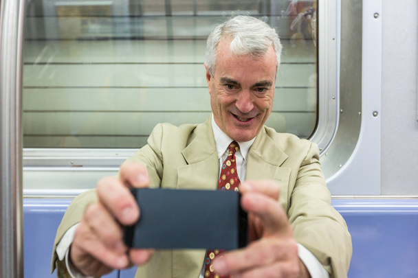 Senior Businessman Taking a Selfie in the Subway Train - Photo, Image