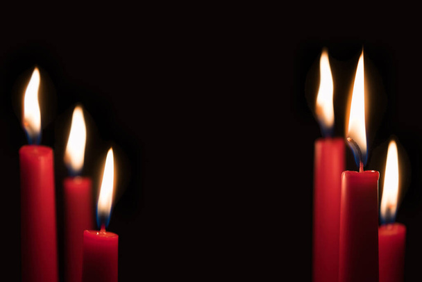 Κόκκινα κεριά μπροστά από το μαύρο φόντο στούντιο με αντίγραφο χώρο στο κέντρο της εικόνας - Φωτογραφία, εικόνα
