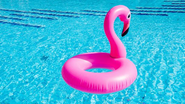 Тропический фламинго. Розовый надувной фламинго в воде для летнего пляжного фона. Вечеринка у бассейна. - Фото, изображение