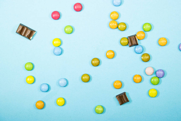 čokoládové tyčinky kousky mléka a sladkosti izolované na modrém pozadí - Fotografie, Obrázek
