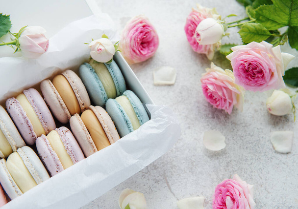 Doos met heerlijke kleurrijke macarons en rozenbloem - Foto, afbeelding