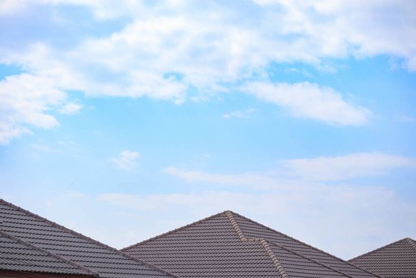Keramische dakpannen op het huis met blauwe lucht - Foto, afbeelding