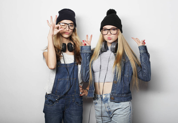 lifestyle, emotion and people concept: Two young girl friends standing together and having fun. - Фото, изображение