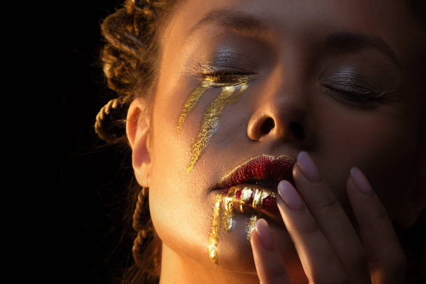 Yüzünde altın damlalar olan gizemli bir kadın kahraman., - Fotoğraf, Görsel
