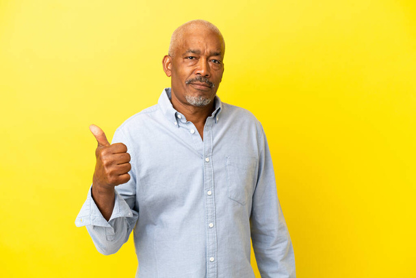 Cuban Senior isolated on yellow background unhappy and pointing to the side - Foto, Imagem