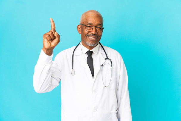 Senior doctor man isolated on blue background pointing up a great idea - Photo, Image