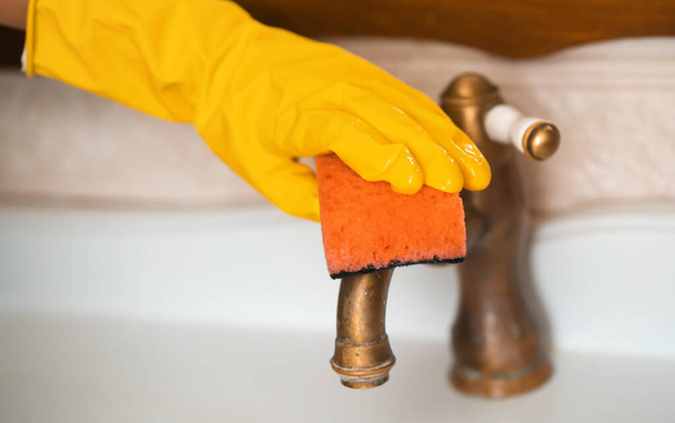 Girl in rubber gloves is cleaning bathroom. - Photo, Image