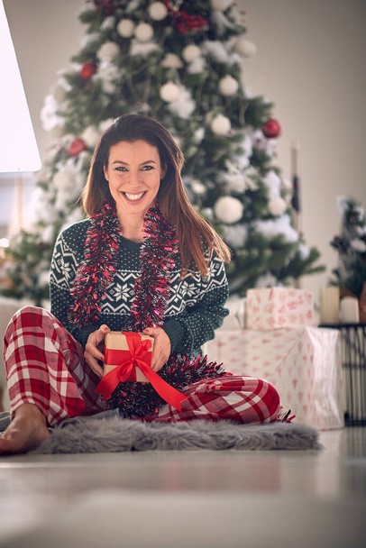 Festive caucasian woman opening gifts on a Christmas morning - Foto, immagini
