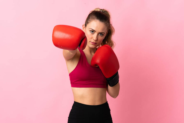 Young Brazilian woman isolated on pink background with boxing gloves - 写真・画像