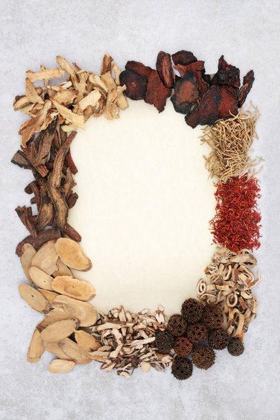 Chinese herbs and spice used in natural herbal plant medicine for traditional healing remedies. On parchment and mottled grey background with copy space.  - Foto, Imagen